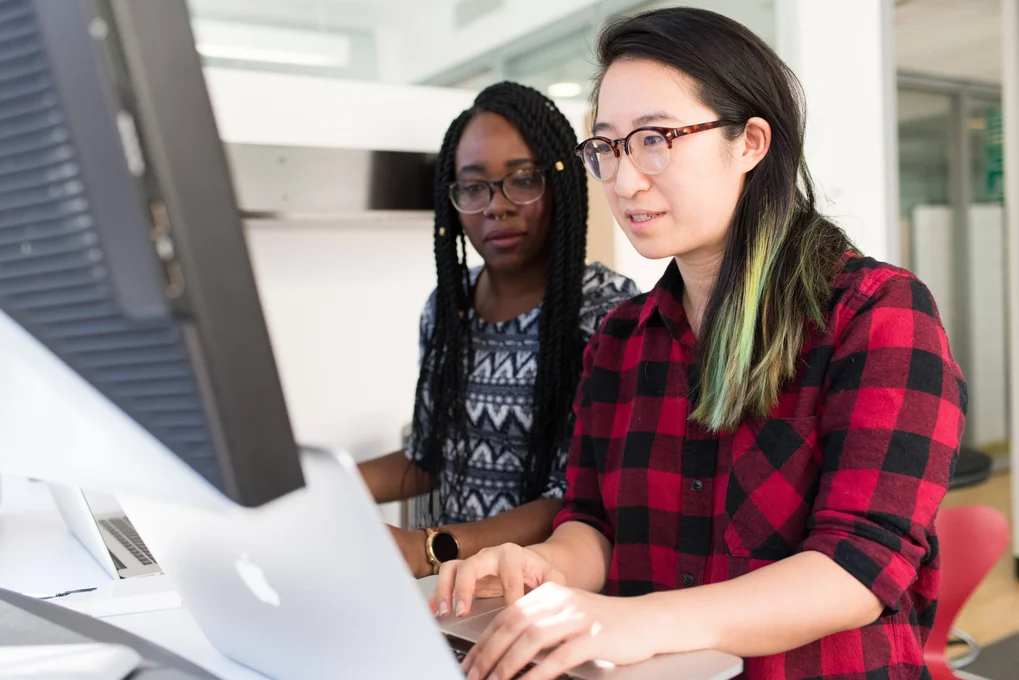 Two students reviewing information on a computer screen.