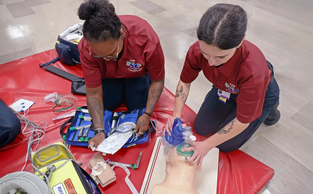 Two EMT - Paramedic students practice emergency medical and lifesaving skills.