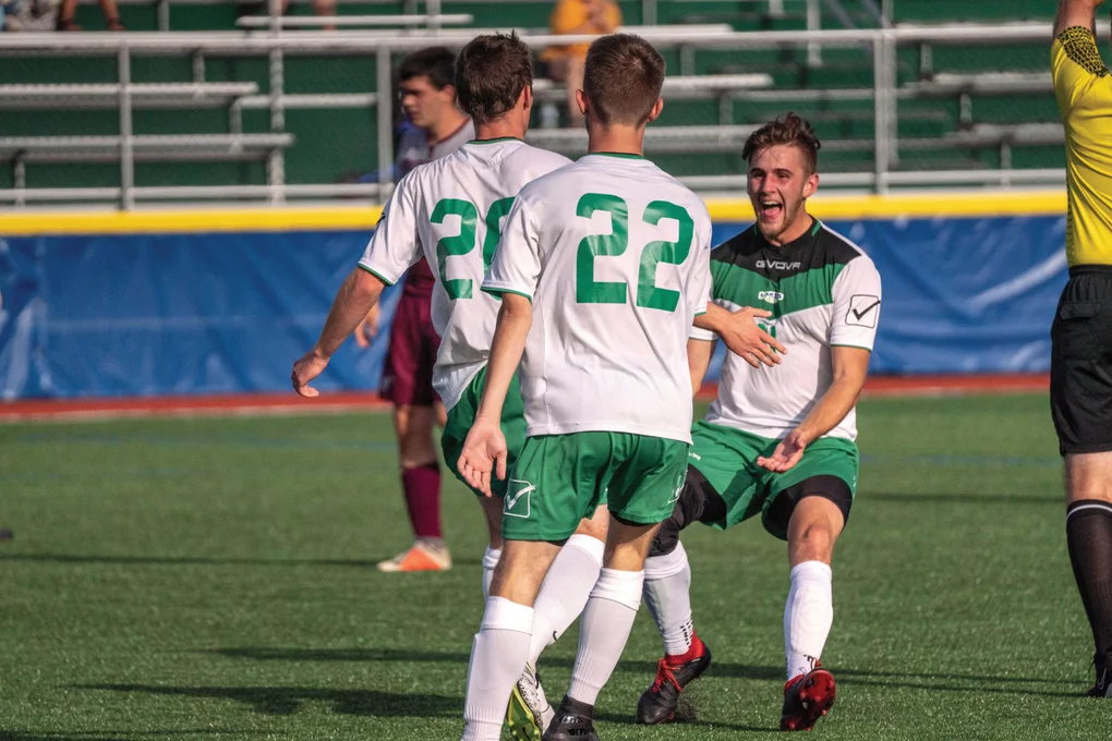 Members of the FLCC men's soccer team gathering on the field during a match.