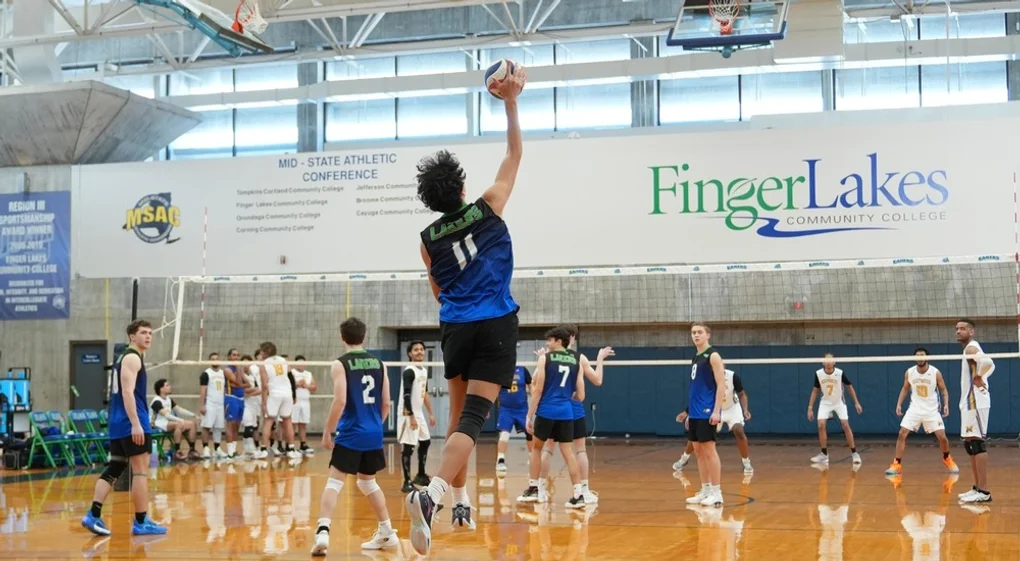 A male volleyball player jumps to reach a ball