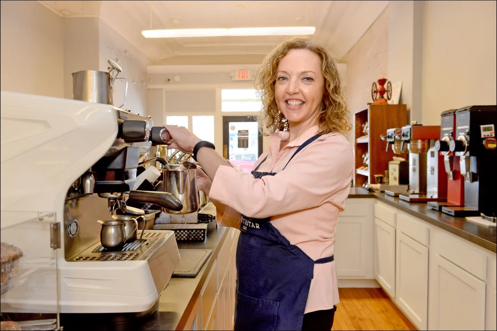 Woman working coffee machine at cafe