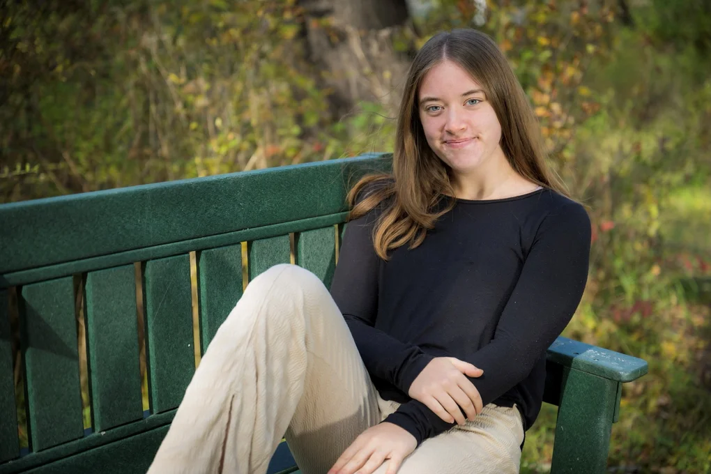Young woman posing on a bench outdoors
