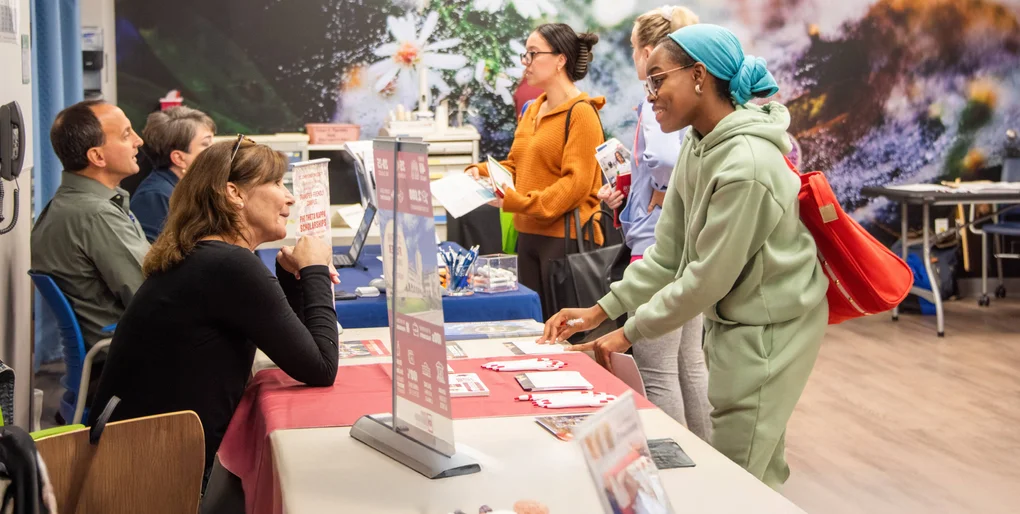 Students meeting with representatives from regional four-year colleges during a transfer event.