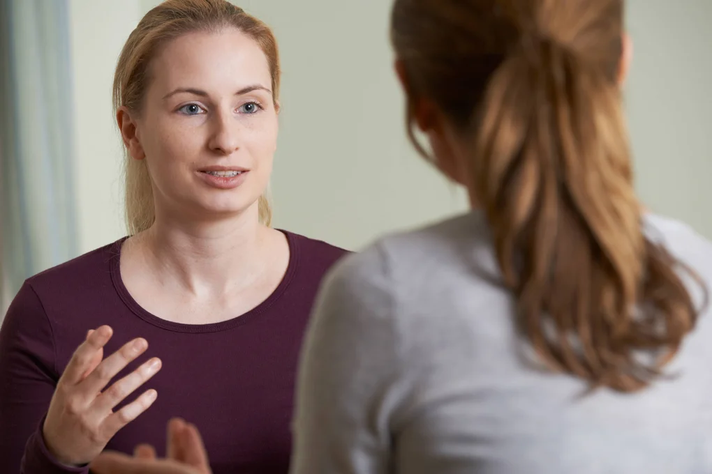 A counselor listens attentively as a patient is speaking.