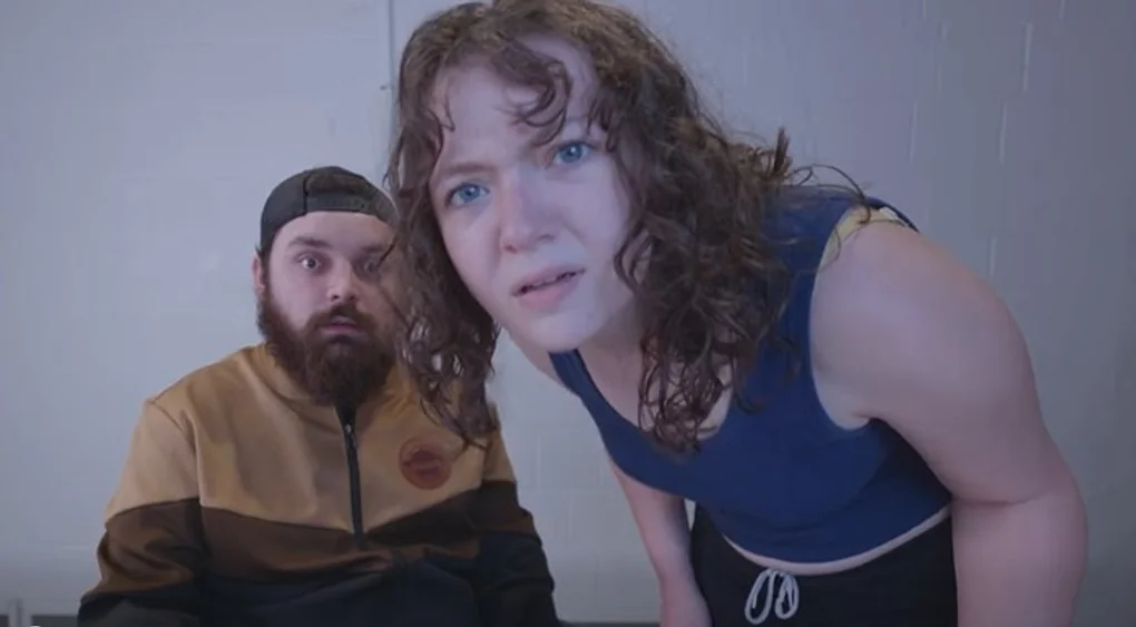 Man and woman peering into camera