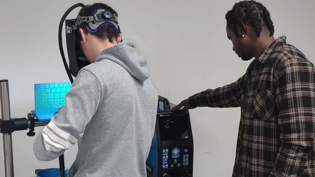 Student wearing visor engaged in simulation with instructor watching