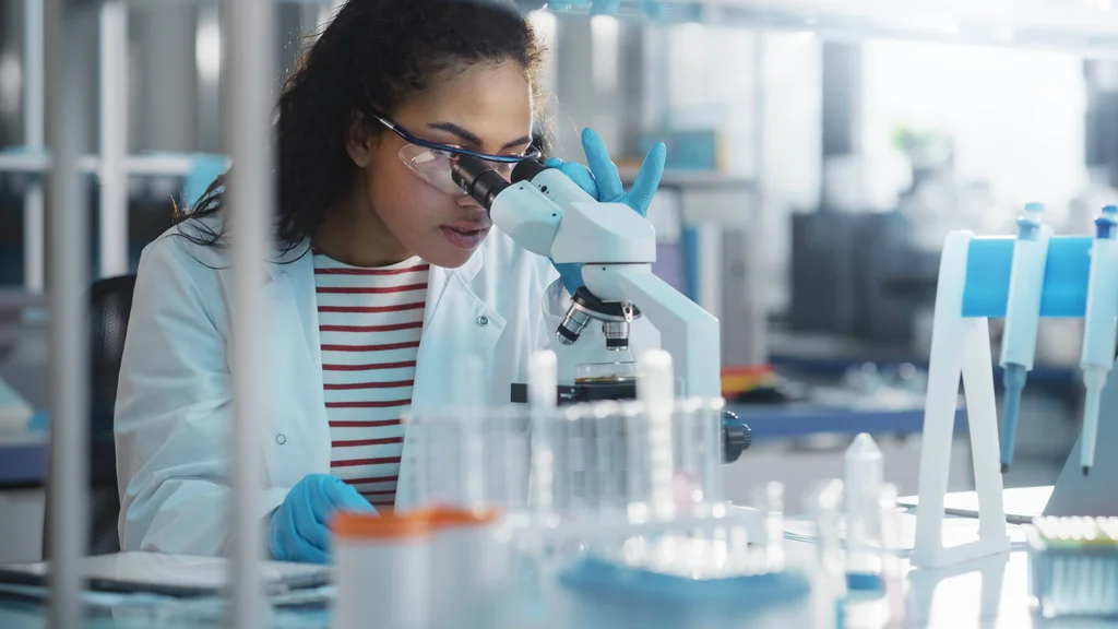 Biotech scientist uses a microscope in a laboratory.