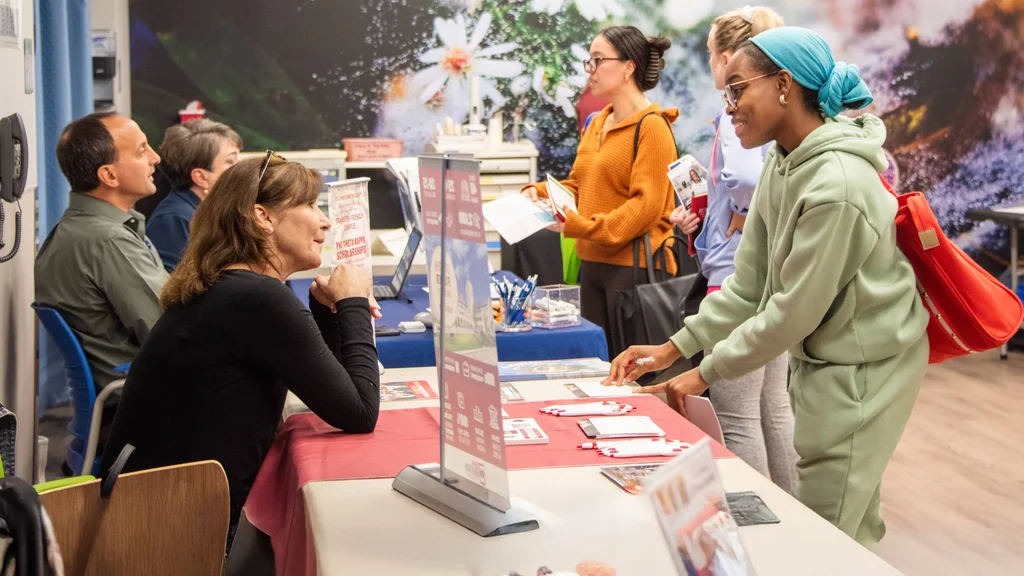 Students meeting with representatives from regional four-year colleges during a transfer event.