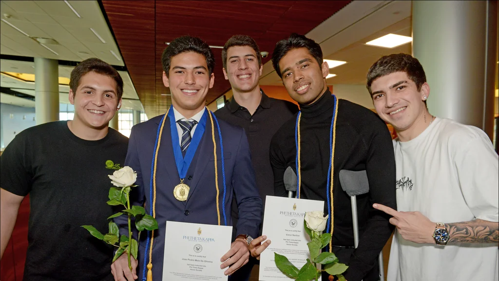 Students posing for a photograph at a Phi Theta Kappa Induction ceremony in 2024
