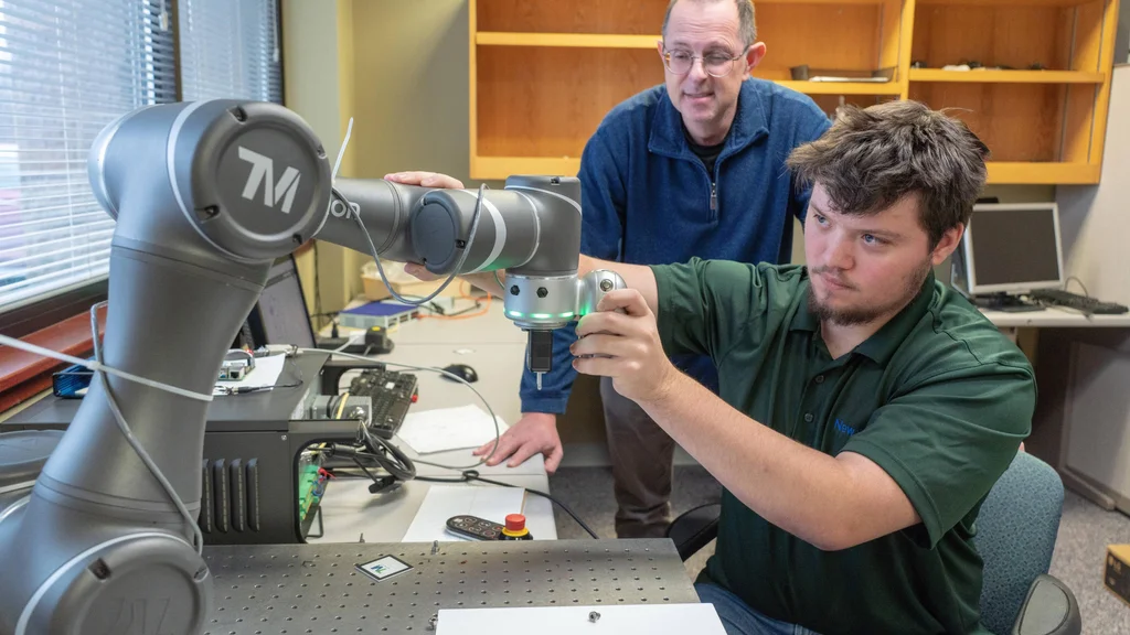 An FLCC student and faculty member work on a project using advanced manufacturing technology.