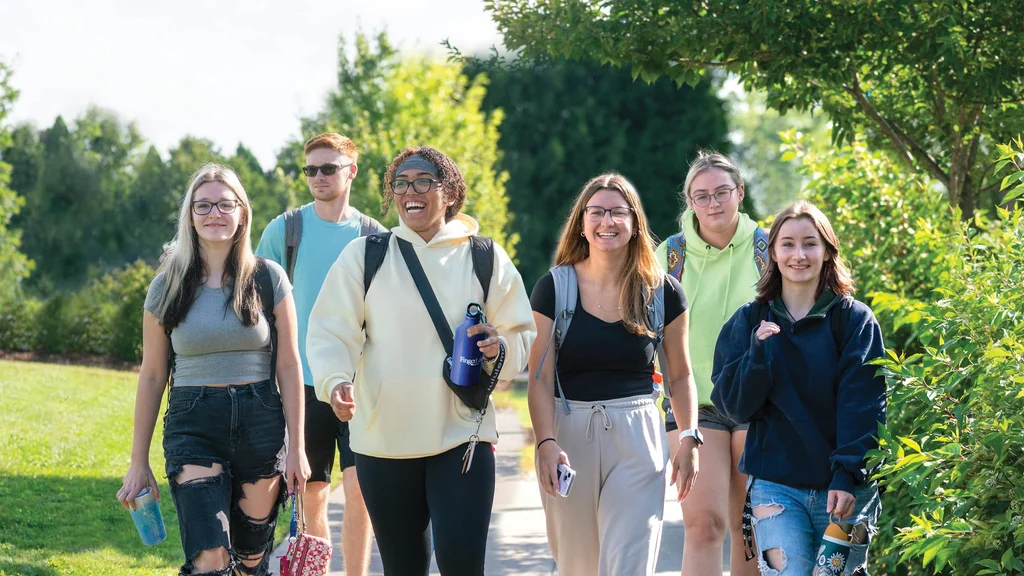 FLCC students walking toward campus on a bright, summer day.