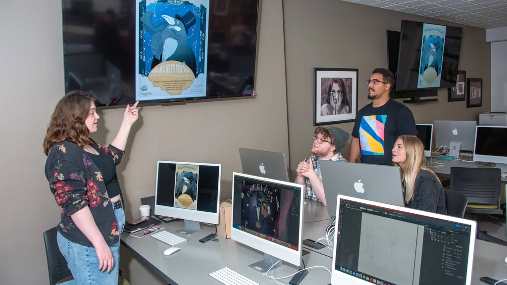 Students in Graphic Arts lab reviewing designs for the Spring Arts Festival competition.