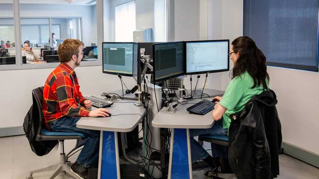 Students in computer lab using dual screen monitors.