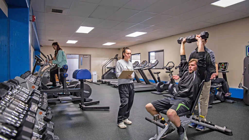 Kinesiology and Human Performance students in athletic training room evaluating a fitness routine.