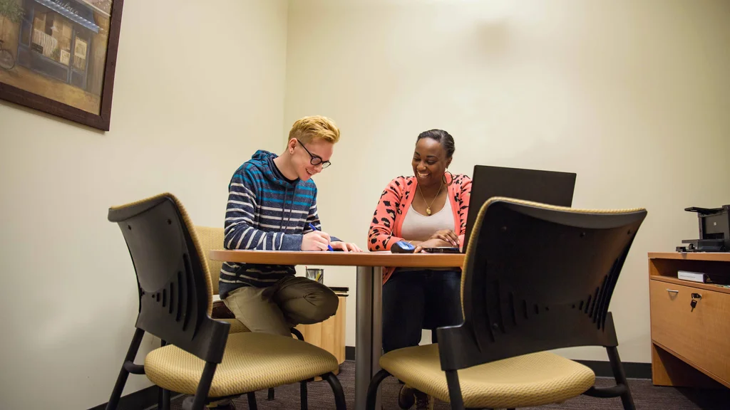An FLCC student and admissions counselor completing college paperwork together.