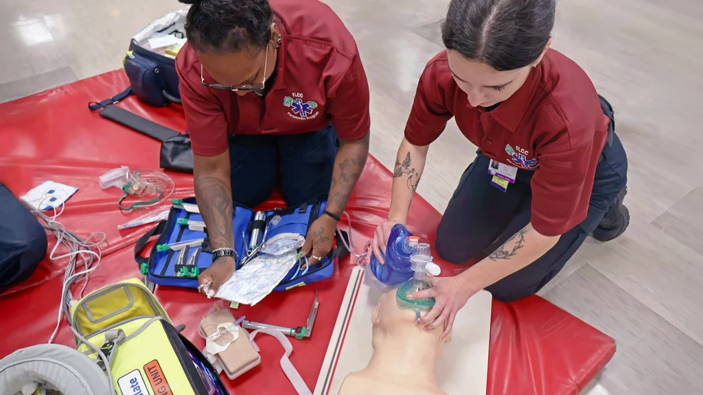 Two EMT - Paramedic students practice emergency medical and lifesaving skills.