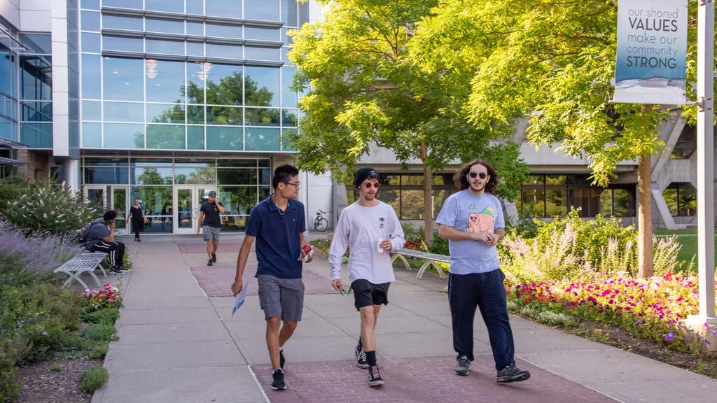 Four prospective students walking outside main campus, attending one-on-one Admissions Counselor appointments at FLCC.