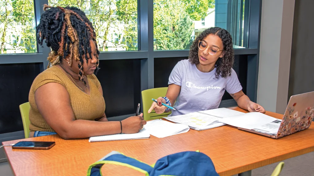 An FLCC student works her coursework with the help of a tutor.