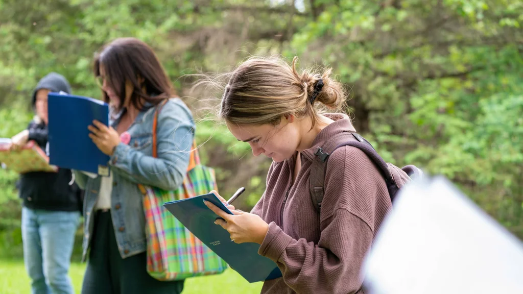 A group of first-year FLCC student taking notes while exploring FLCC's main campus.