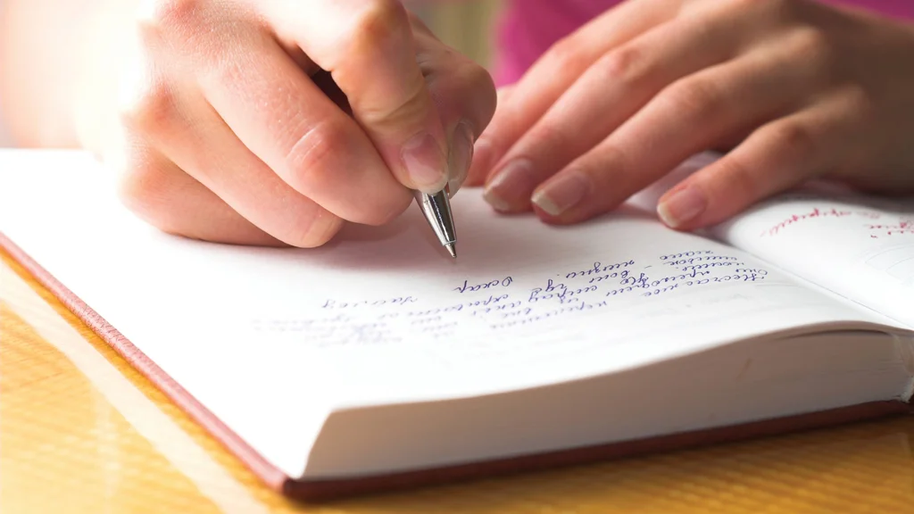Student writing in a notebook.