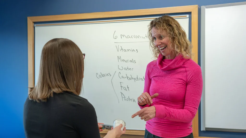 A nutrition and dietetics student talking to faculty after class.