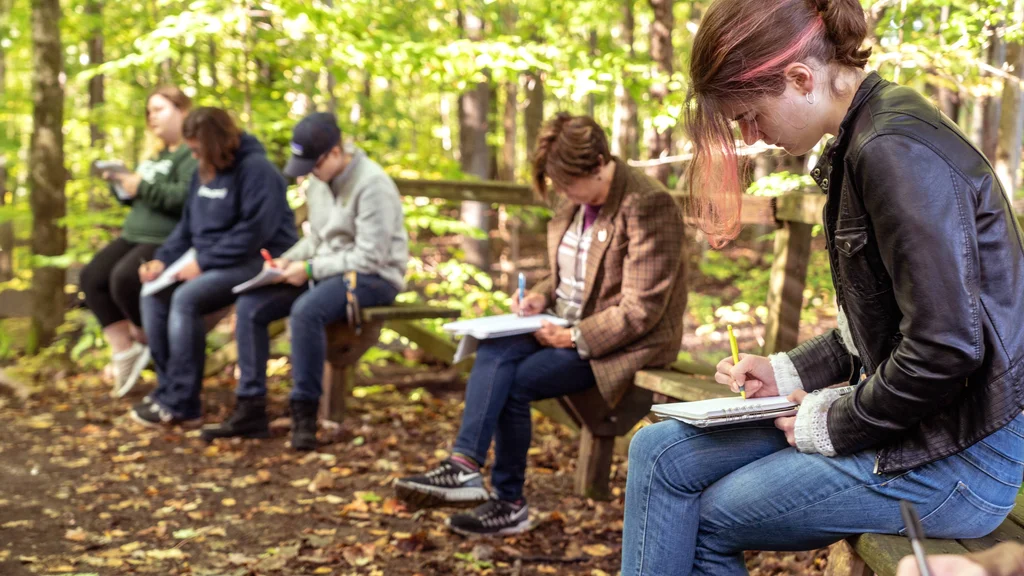 Creative Writing students work on a writing assignment in FLCC walking trails.