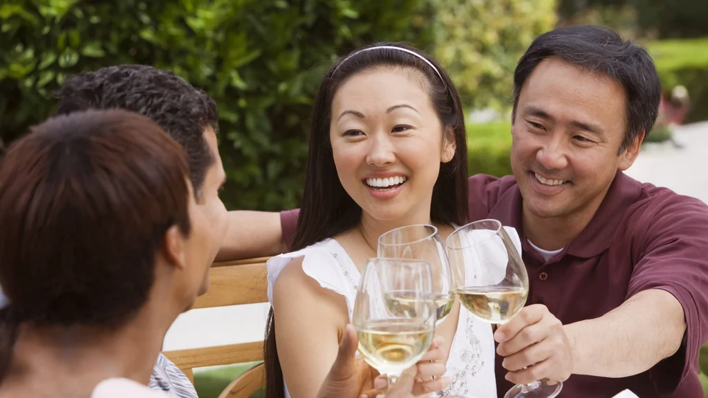 A group of friends gather to enjoy a glass of white wine.