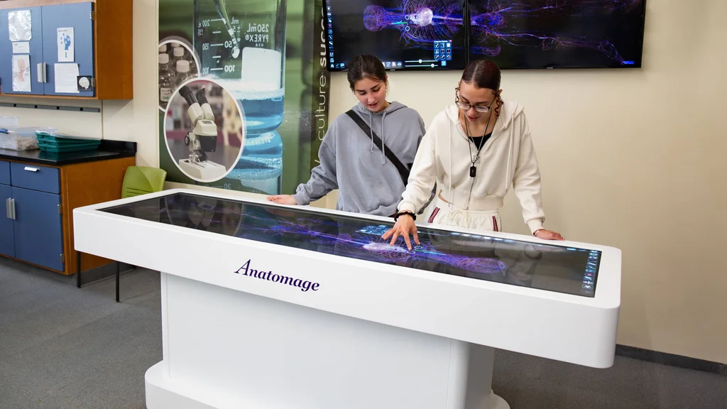 Two nursing students work together in the Incubator using the Anatomage, which is high-tech learning equipment to train future healthcare workers.