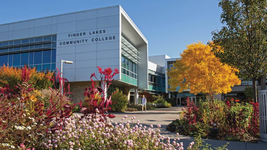 Student walking on campus in the fall at the FLCC main campus in Canandaigua.