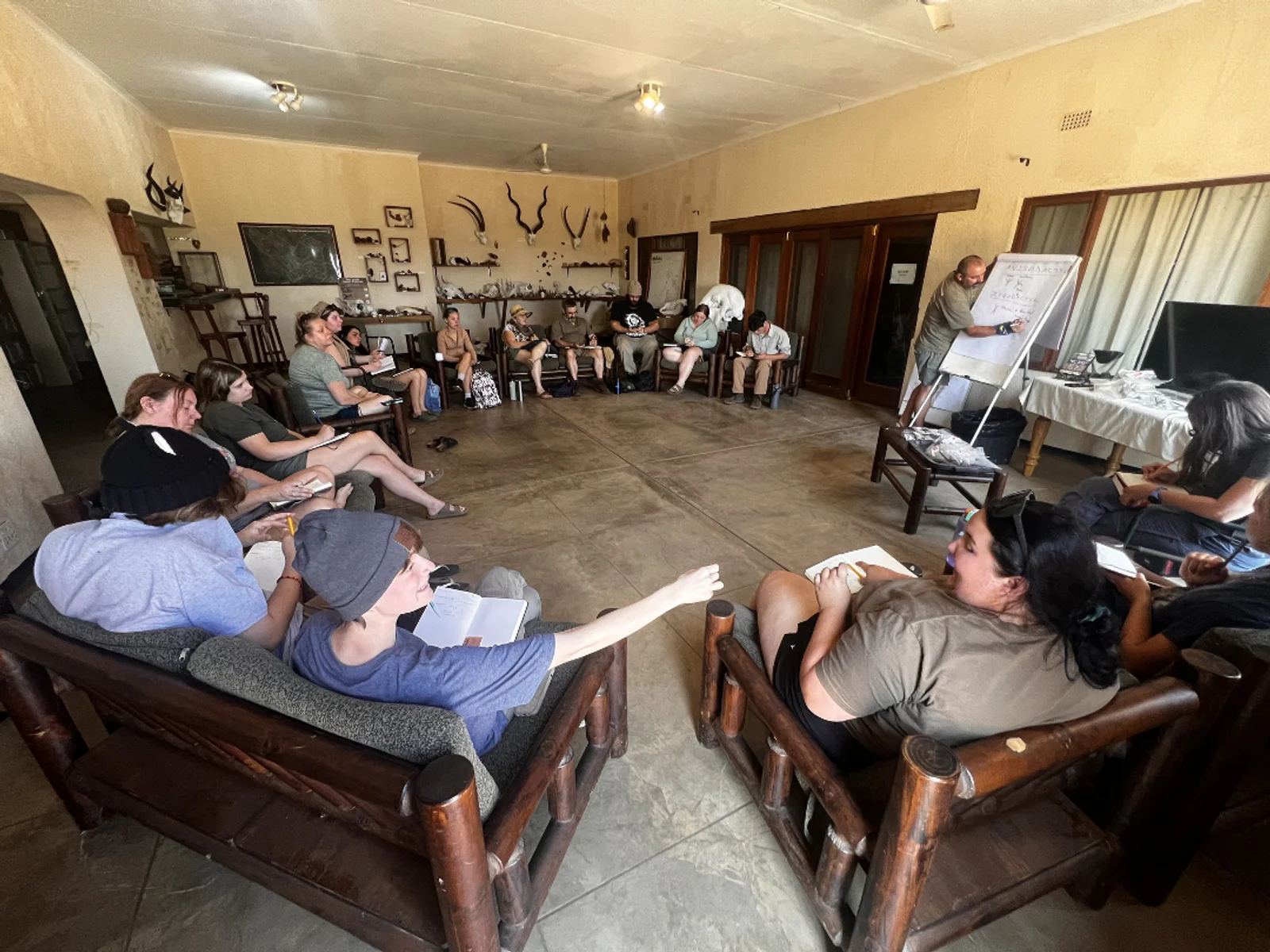 Faculty and students pose for a photo in front of a street sign.