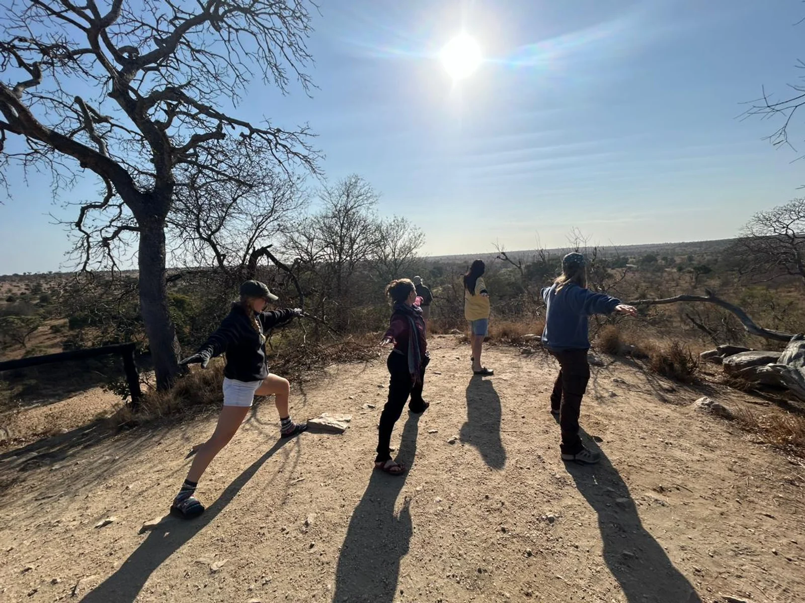 Faculty and students pose for a photo in front of a street sign.
