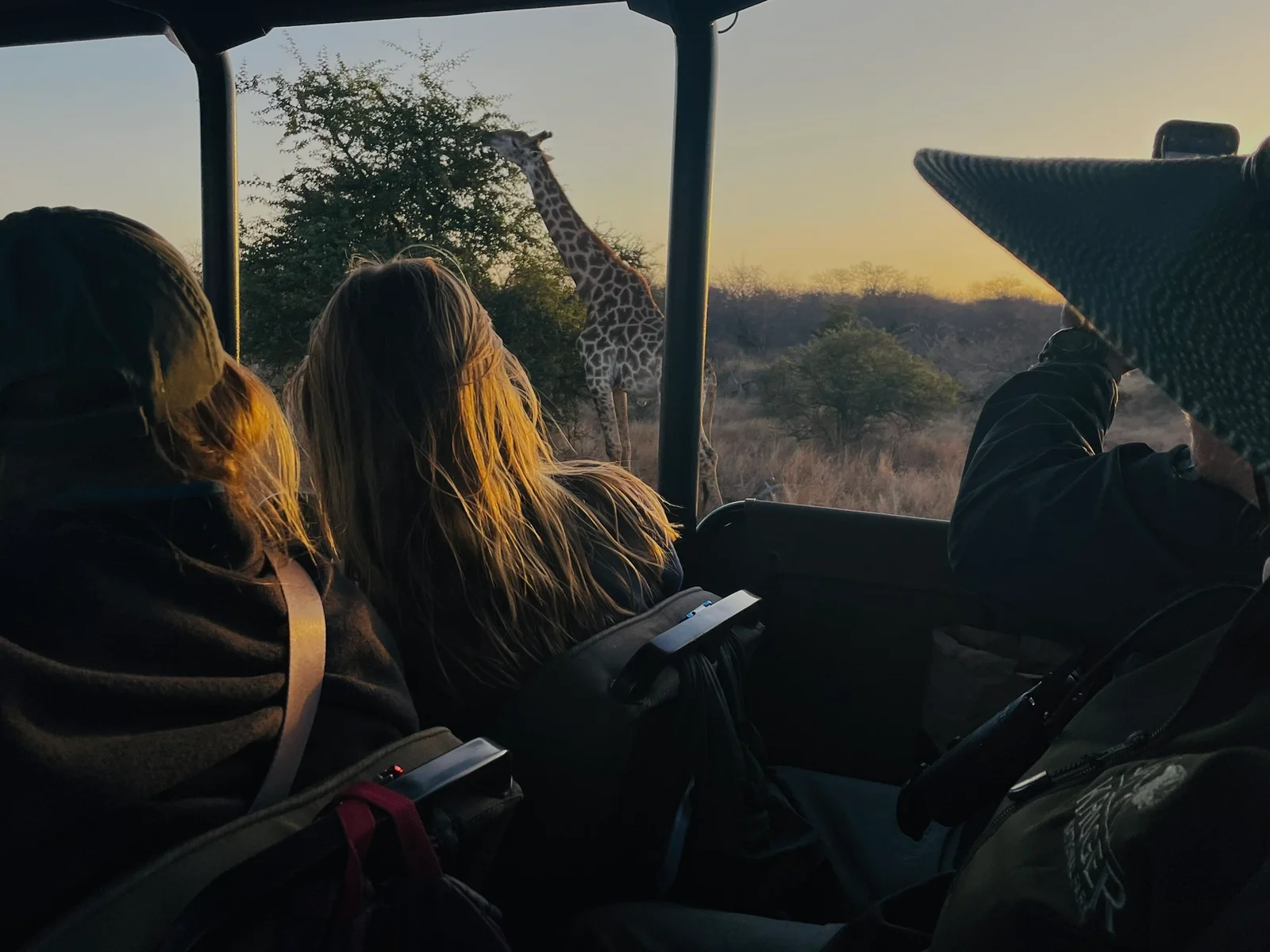 Faculty and students pose for a photo in front of a street sign.