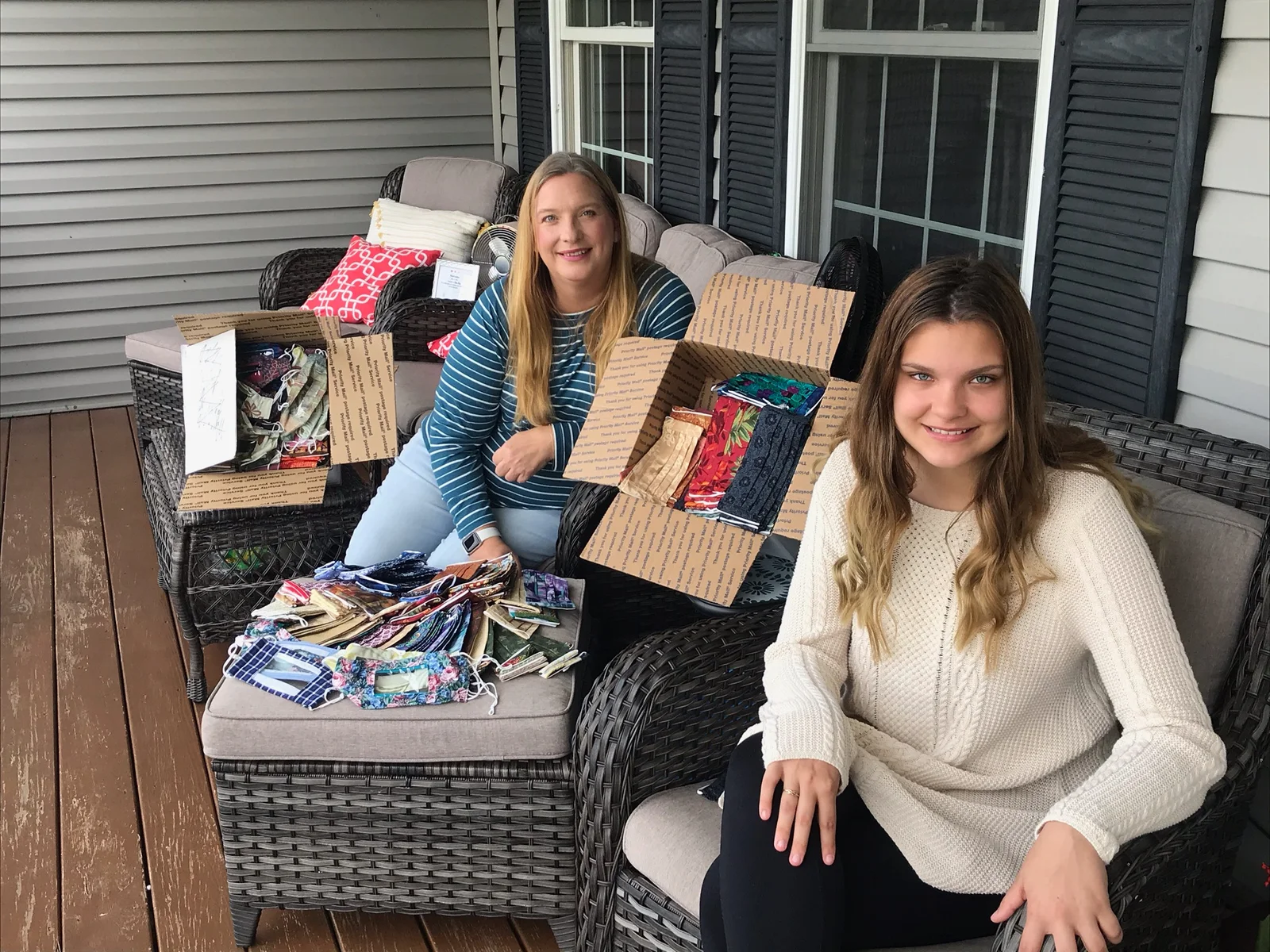 mom and daughter with face coverings on a porch