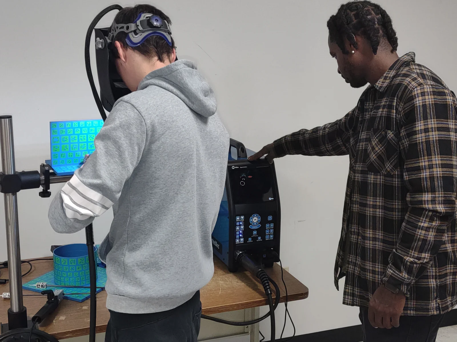 Student wearing visor engaged in simulation with instructor watching