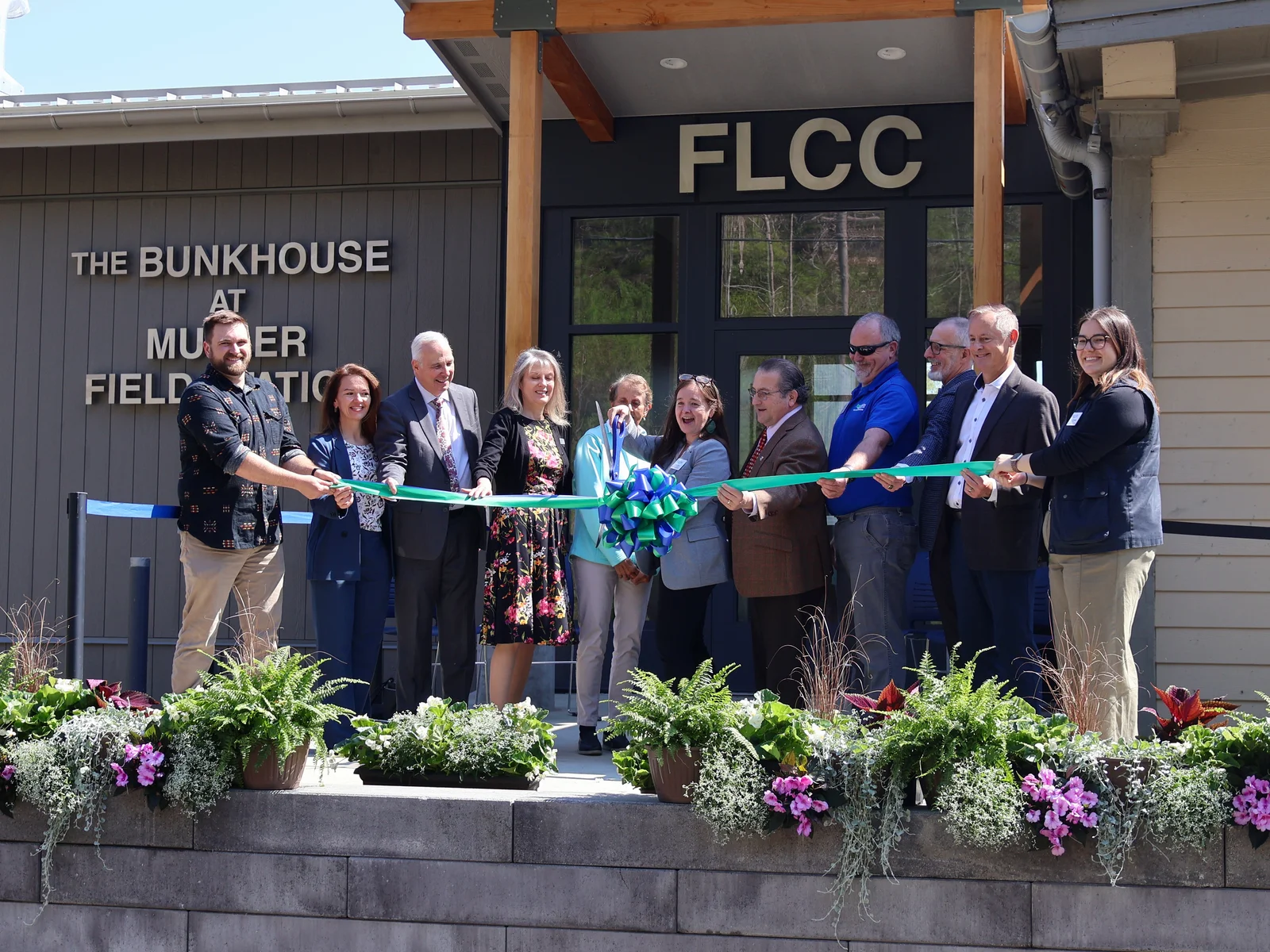 Eleven representatives gather to cut the ceremonial ribbon.