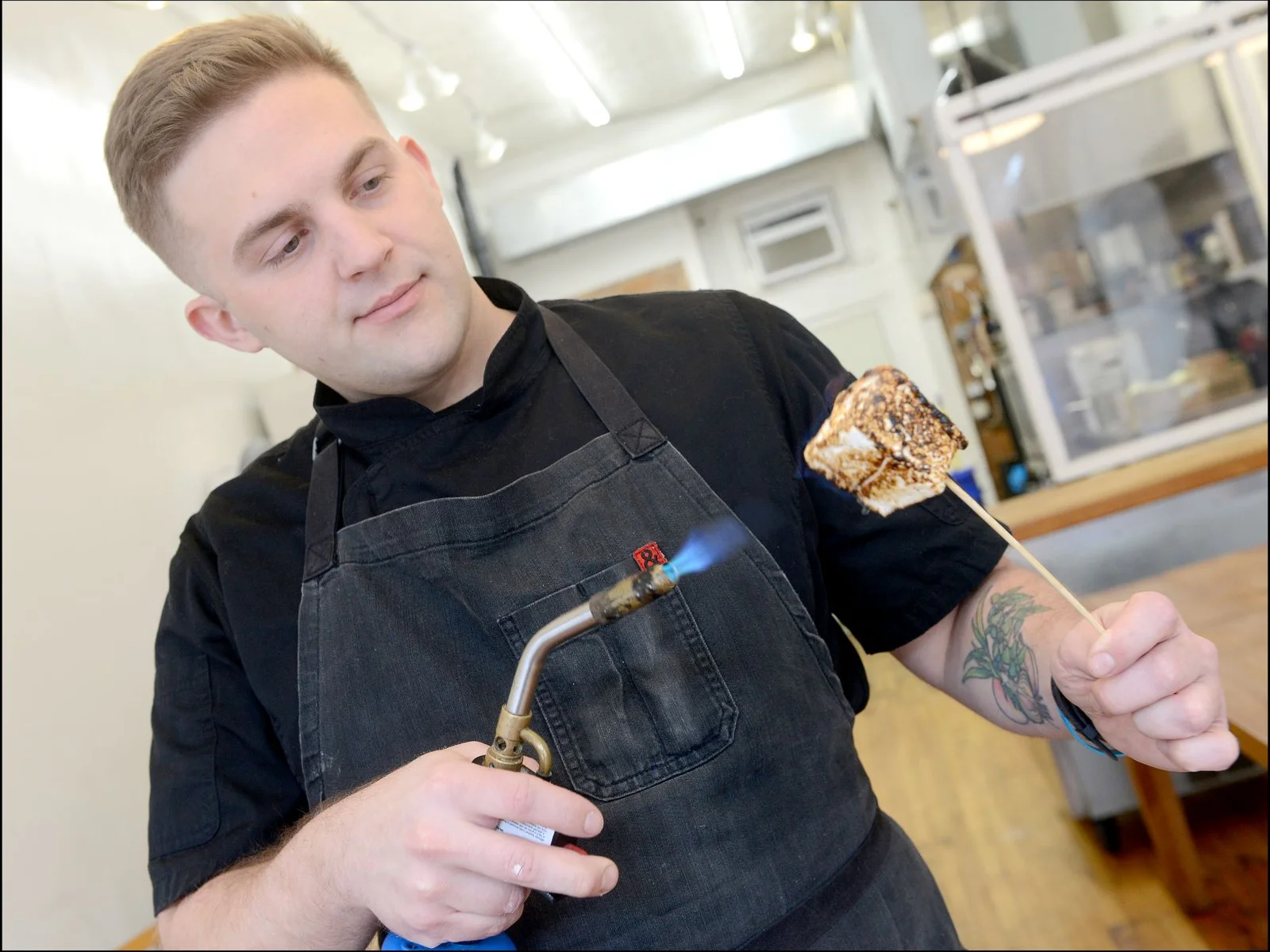 Gary Parmelee roasting a marshmellow dessert with torch