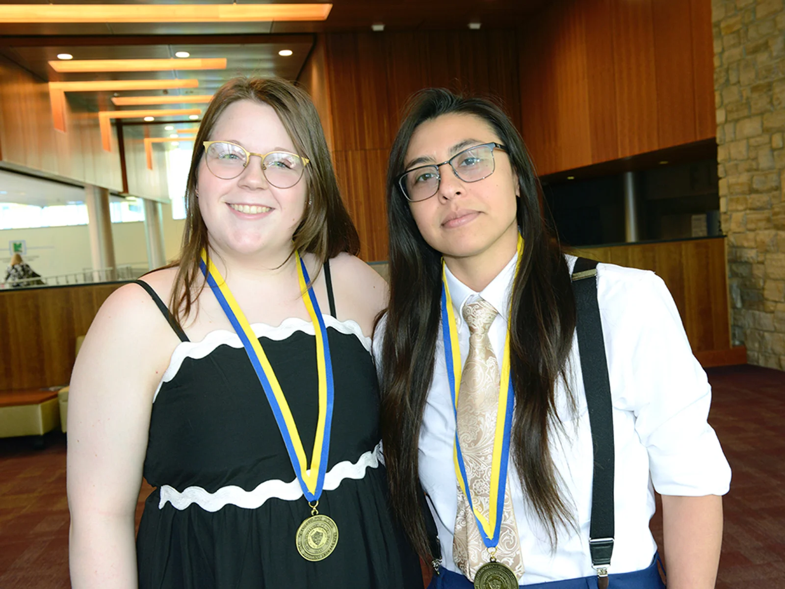 Two women posing, wearing medals