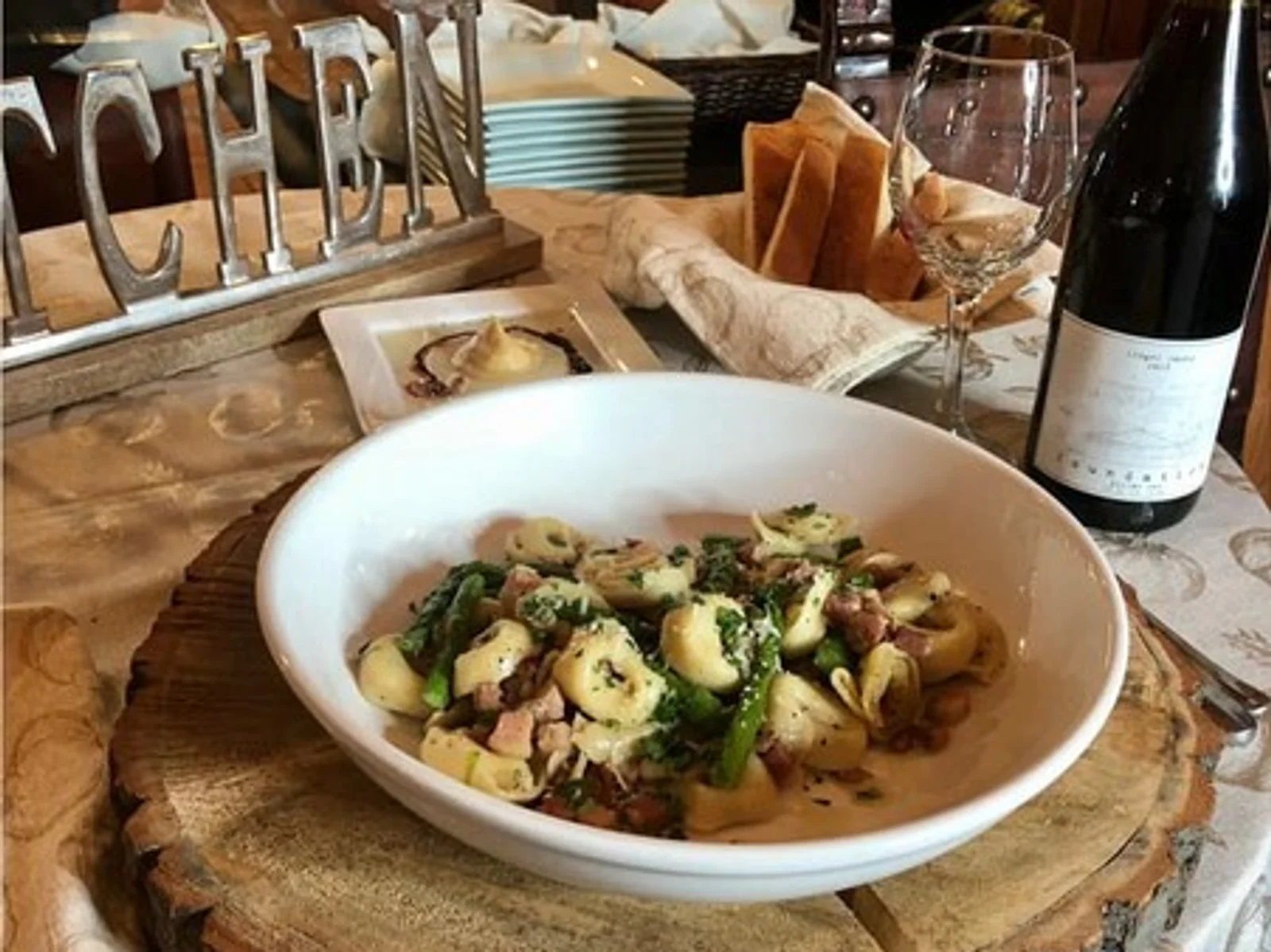 Dish of fancy pasta with wine bottle