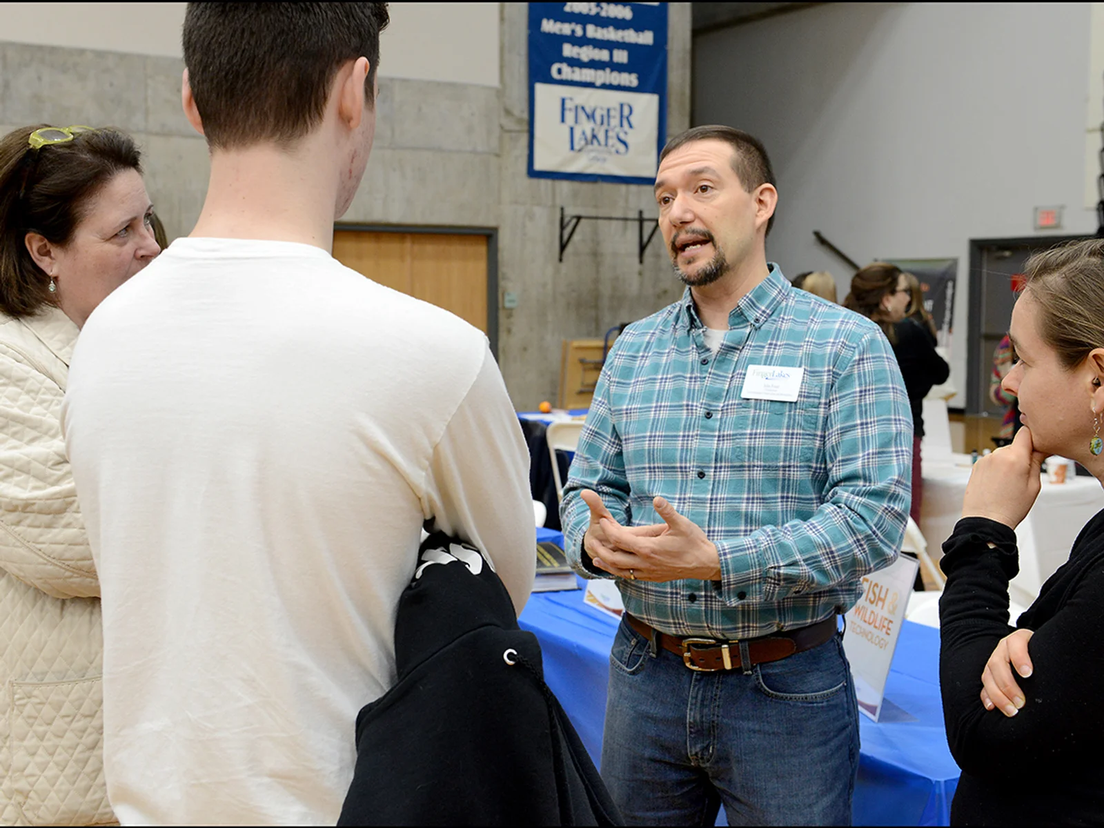 John Foust, standing, talking to three people