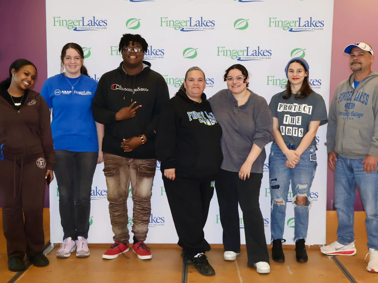 7 students posing in front of an FLCC banner