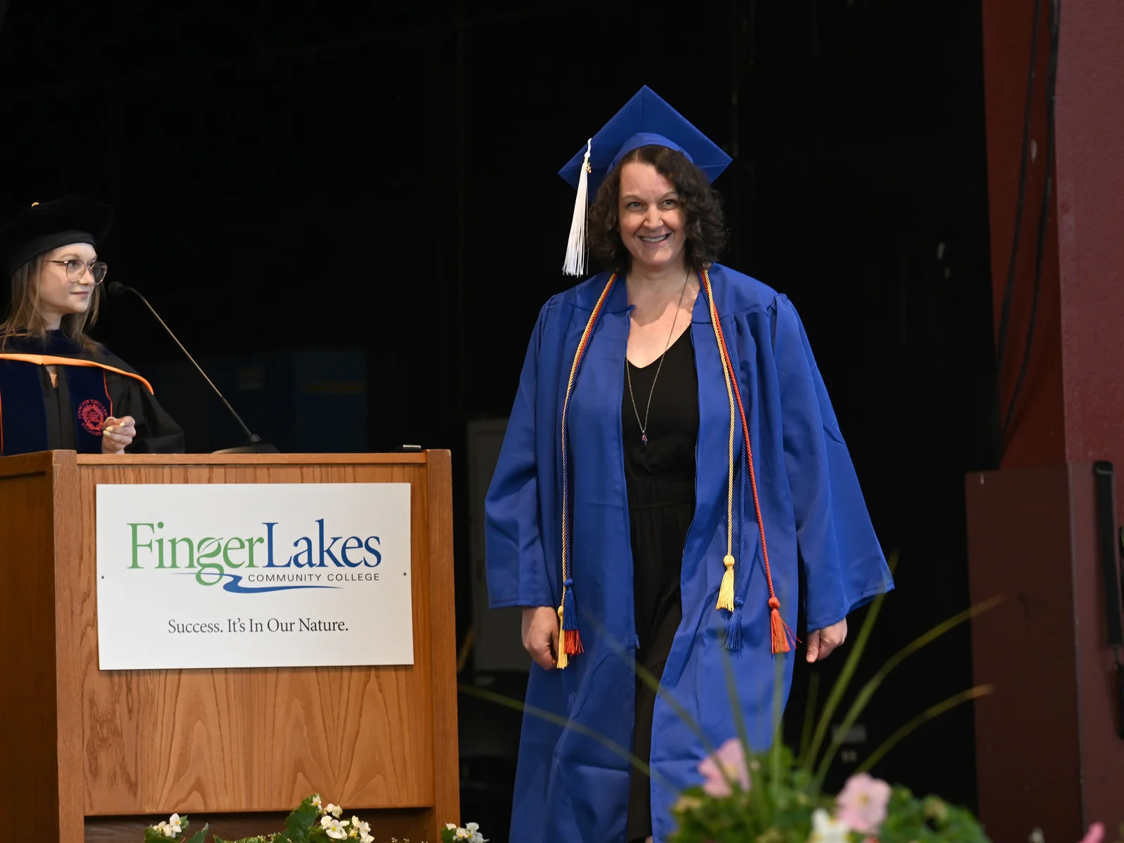 Woman in graduation cap and gown ready to walk across the stage