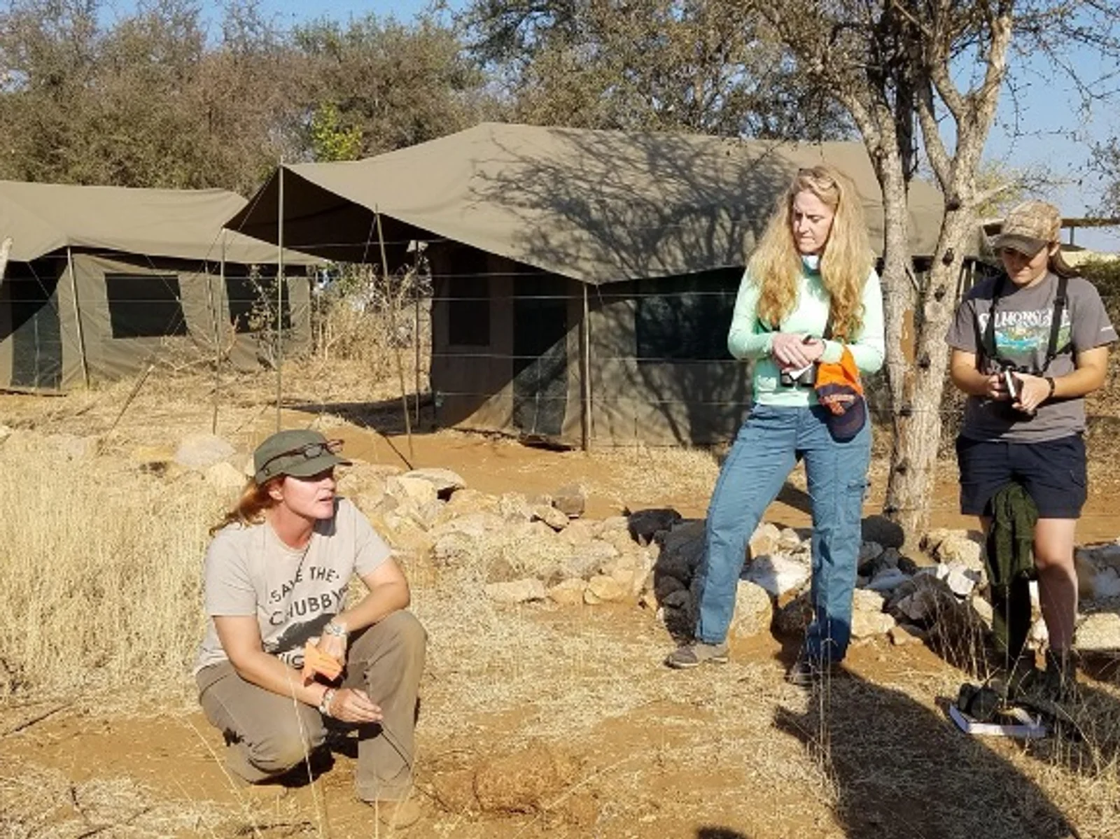 Faculty and students pose for a photo in front of a street sign.