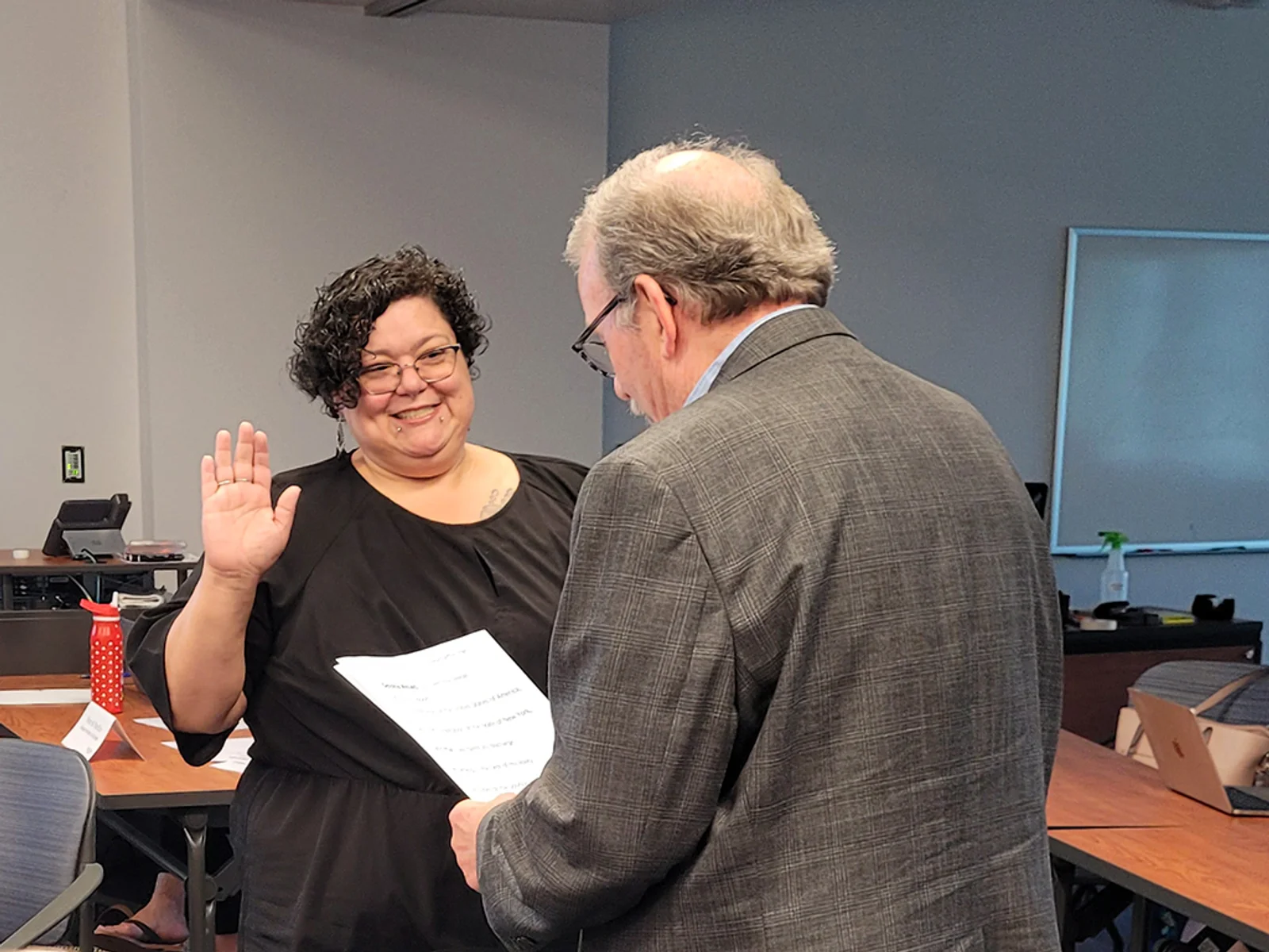 Woman raising hand to be sworn in as trustee