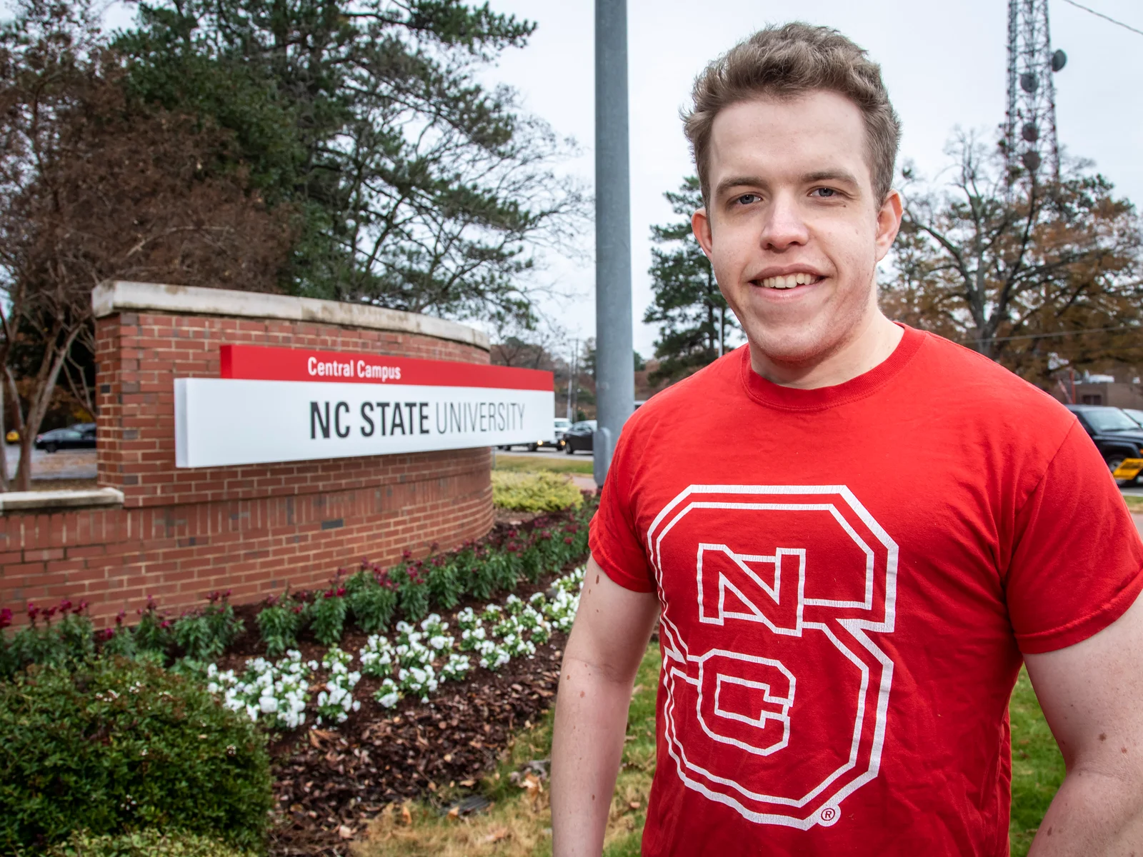 Male student in front of NC State sign