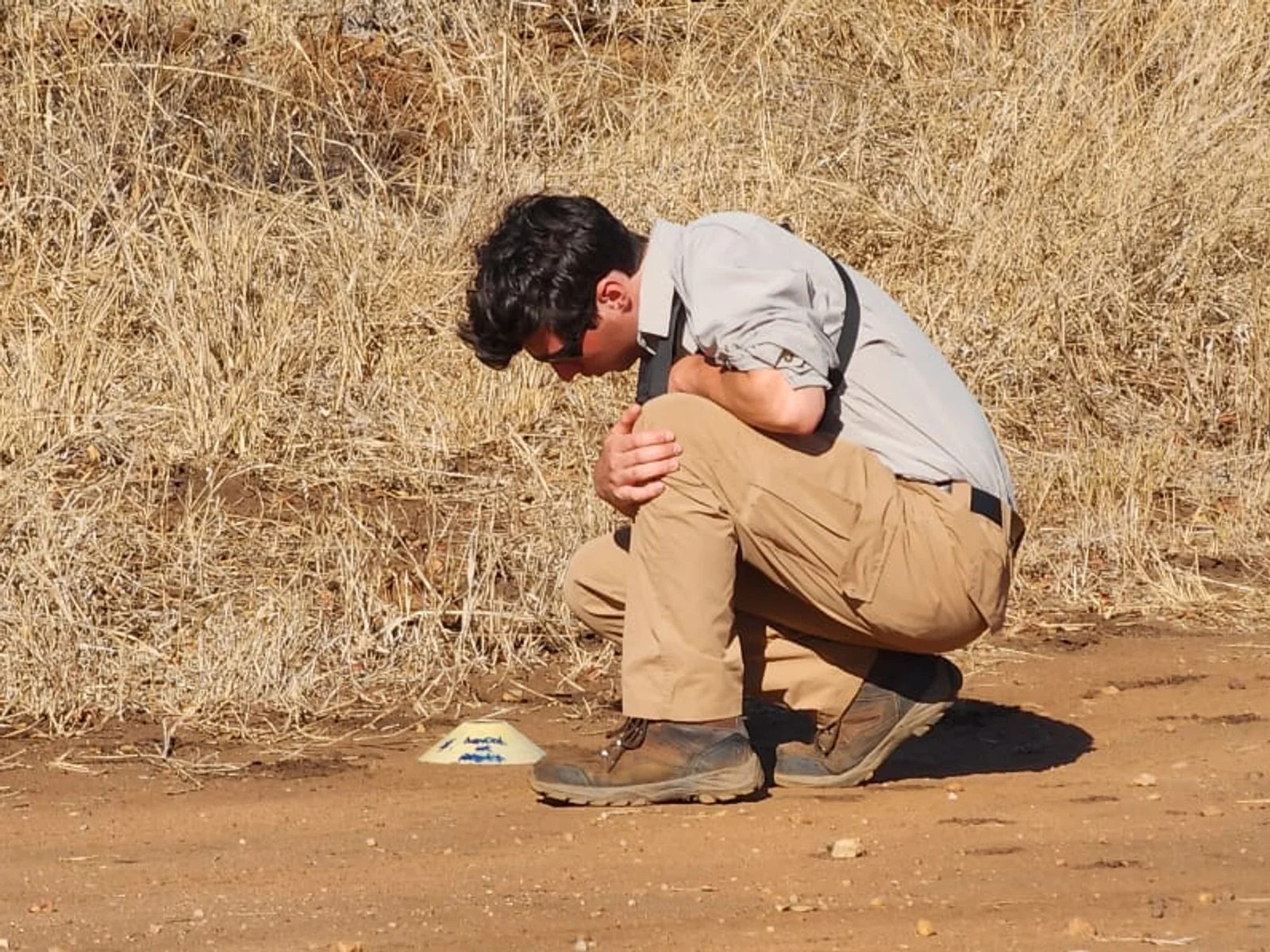 Faculty and students pose for a photo in front of a street sign.