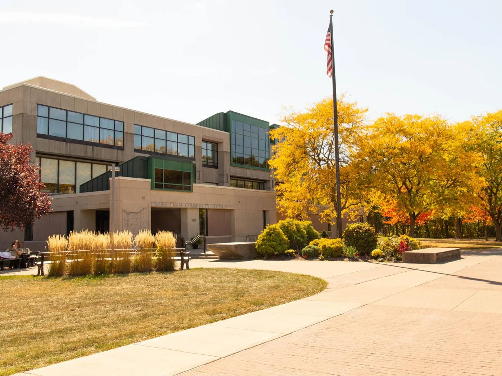 Student relaxing on campus in the fall at the FLCC main campus in Canandaigua.