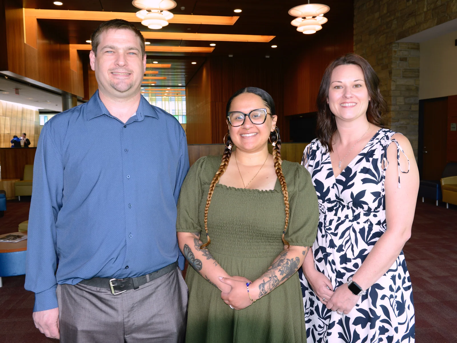 Three individuals posed for a professional photo in the Student Lounge at Finger Lakes Community College.