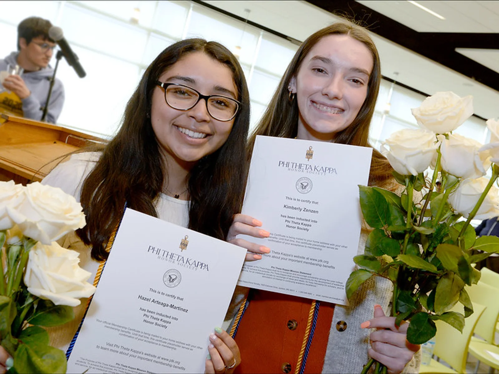 Two students pose with certificates