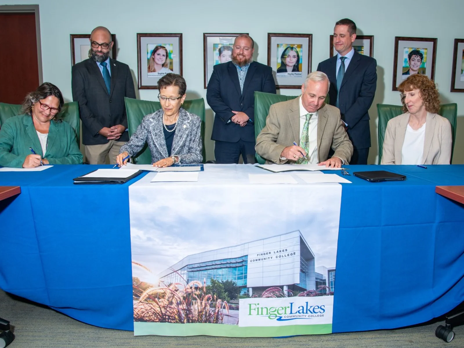 College officials at table signing documents