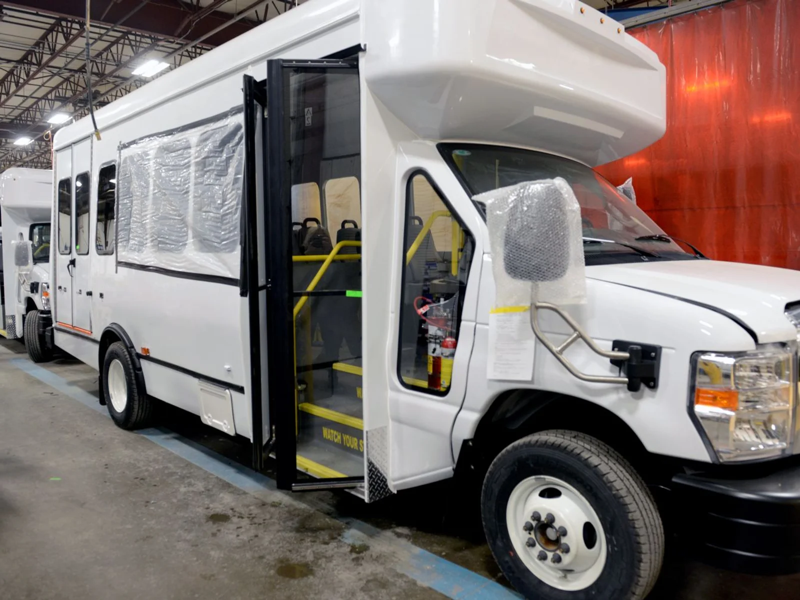 An instructor stands next to a man in a welding helmet using computer simulation technology